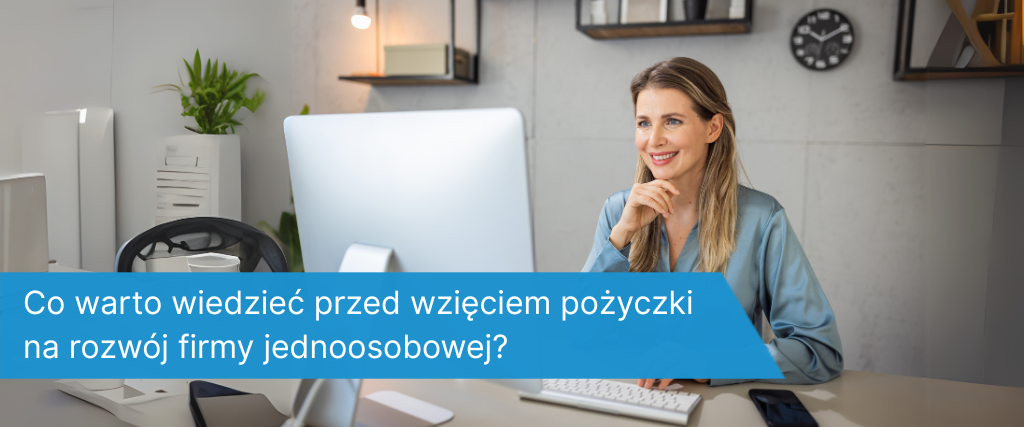 Uśmiechnięta kobieta pracująca przy biurku z komputerem w nowoczesnym biurze