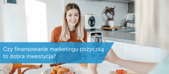 Kobieta nagrywana telefonem podczas tworzenia treści w kuchni, ilustracja do tematu finansowania marketingu pożyczką.